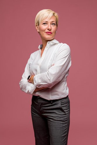 Professionelles Business-Portrait einer selbstbewussten Geschäftsfrau im weißen Hemd vor rosa Hintergrund – moderne Mitarbeiterfotografie